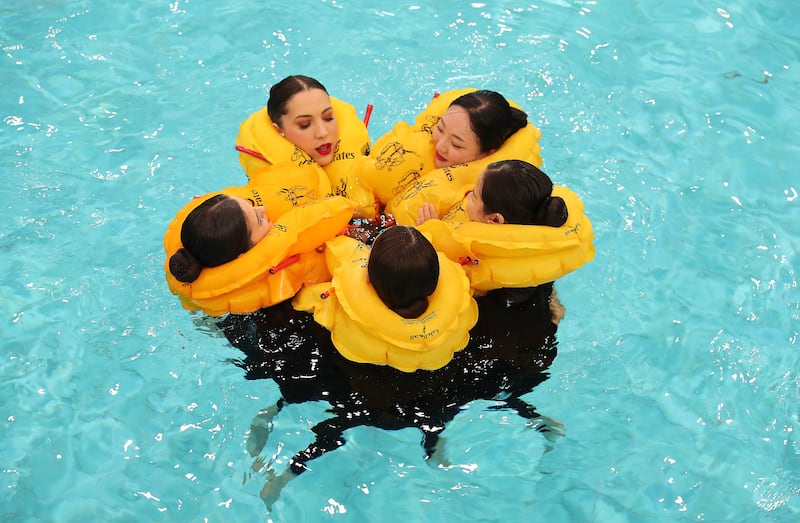 Trainees are taught to huddle in the cold water to conserve heat during an emergency landing on water.