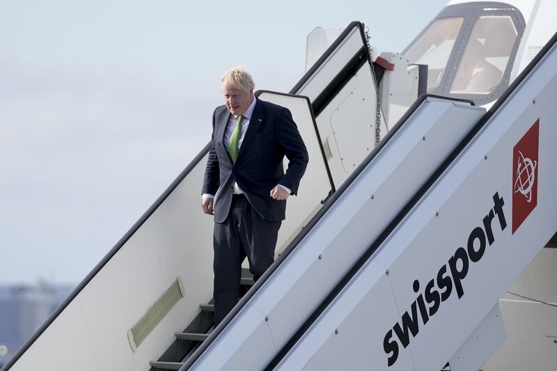 Mr Johnson steps off the plane in Helsinki. PA