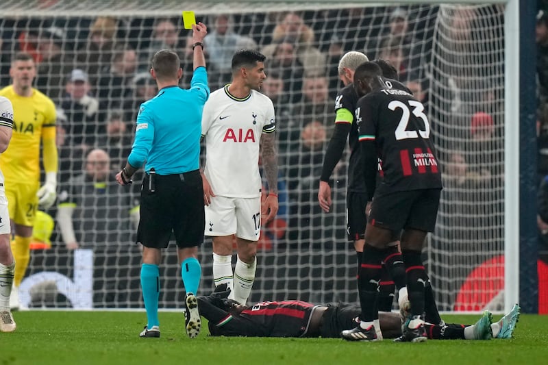Tottenham defender Cristian Romero is shown a yellow card by referee Clement Turpin after a foul on AC Milan's Rafael Leao. AP
