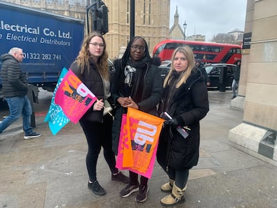 Teachers Katrina Downie, centre, Olga Adock, right, and their colleague pose in front of the UK Parliament following a rally for strking workers. The National