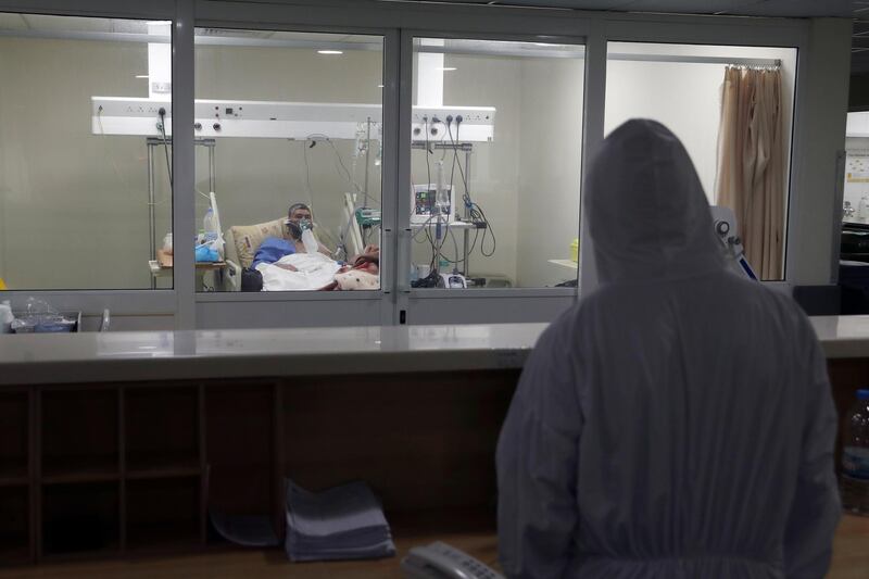 A medical worker looks at a Covid-19 patient in the intensive care unit of the Rafik Hariri University Hospital in Beirut, Lebanon. AP