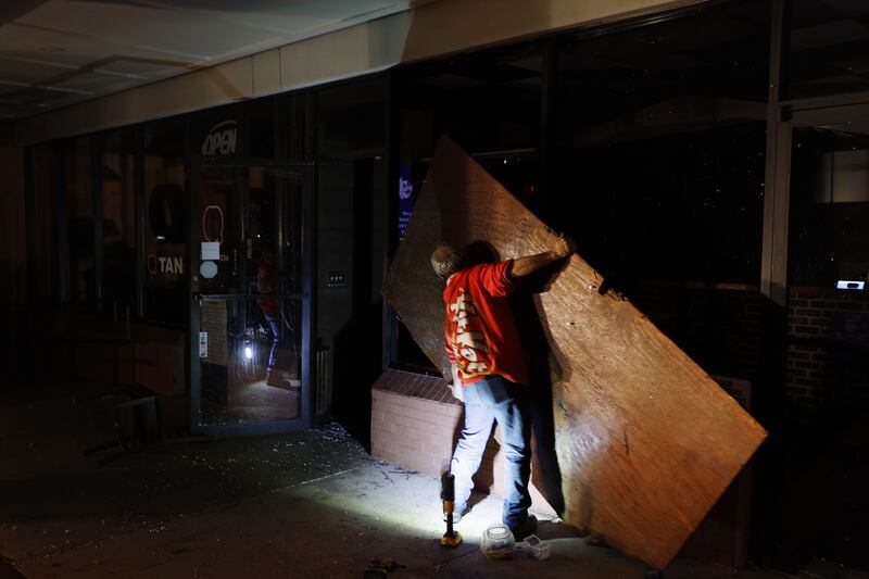 Workers board up the windows of a restaurant damaged by a tornado in Griffin. EPA