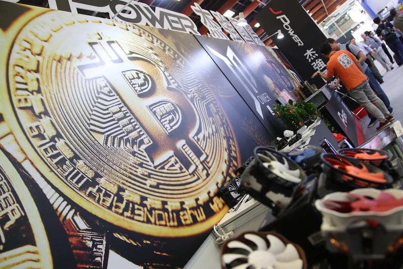 epa06785821 A bitcoin logo is seen next to computer fans during the Computex 2018 in Taipei, Taiwan, 05 June 2018. The Computex 2018 event will run from 05 June to 09 June 2018 and will exhibit innovations from various computer designers.  EPA/RITCHIE B. TONGO