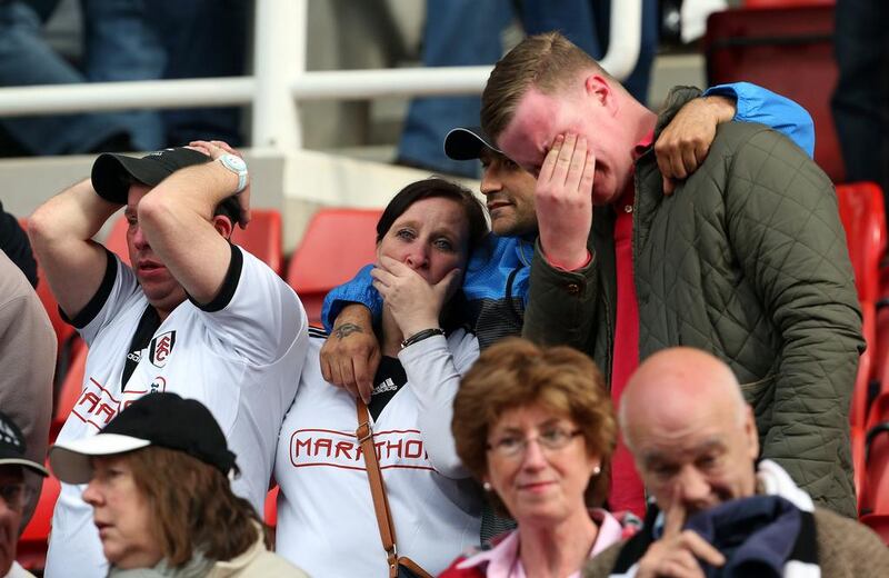 Fulham fans show their emotions following defeat and subsequent relegation. Geoff Caddick / AFP