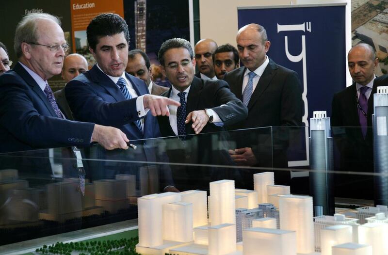 The chairman of Dubai’s Emaar Properties Mohamed Alabbar (centre) and the prime minister of the Kurdistan regional government, Nechirvan Barzani, (second from left) look at the architecural model of the “Downtown Erbil”.  AFP PHOTO / SAFIN  HAMED