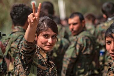 A female fighter of the US-backed Kurdish-led Syrian Democratic Forces flashes the victory gesture while celebrating near the Omar oil field in the eastern Syrian Deir Ezzor province. AFP