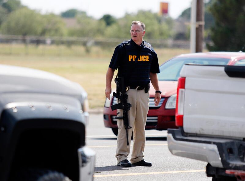 A law enforcement officer stands in the middle of the 5100 block of E. 42nd Street in Odessa, Texas following a shooting at random in the area of Odessa and Midland. Several people were dead after a gunman who hijacked a postal service vehicle in West Texas shot more than 20 people, authorities said Saturday. The gunman was killed and a few law enforcement officers were among the injured. AP