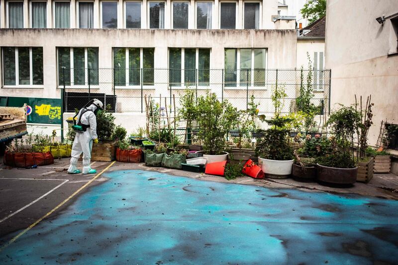 A worker sprays a gel on the ground to absorb lead as he takes part in a clean-up operation at Saint Benoit school near Notre-Dame Cathedral in Paris during a decontamination operation. AFP