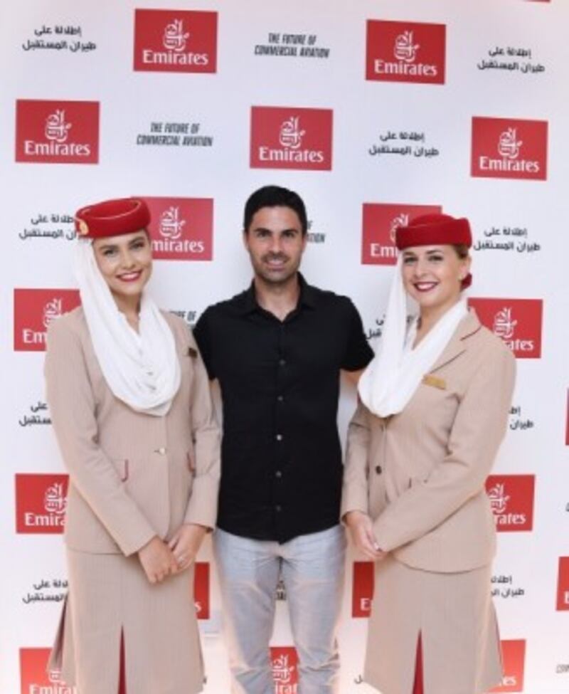 He has his picture taken with Emirates airline hosts at the pavilion.