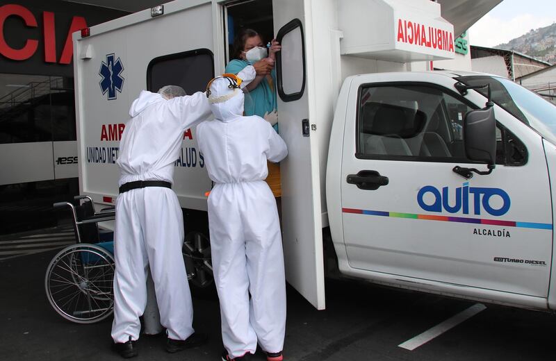 Healthcare workers help a woman out of an ambulance at the emergency entrance of a Covid-19 hospital in Quito, Ecuador. AP