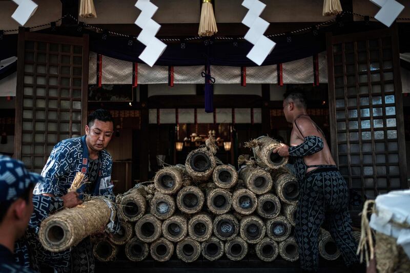 Men piling handmade Tezutsu hanabi which will be purified before being dedicated to the Yoshida Shrine. AFP