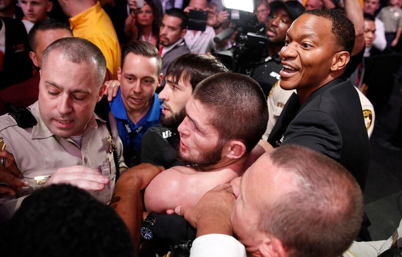 Khabib Nurmagomedov is held back outside of the cage. AP Photo