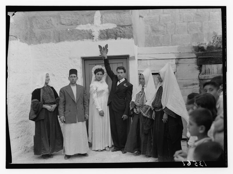 "Ruth" story. Bethlehem bride & groom after wedding touching green. Leaf & yeast above doorway to prospective house, facing camera. G. Eric and Edith Matson Photograph Collection / Library of Congress