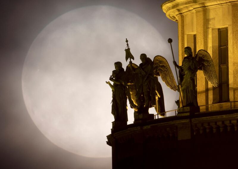 Sculptures on St Isaac's Cathedral are silhouetted as the Moon rises above St Petersburg, Russia. AP