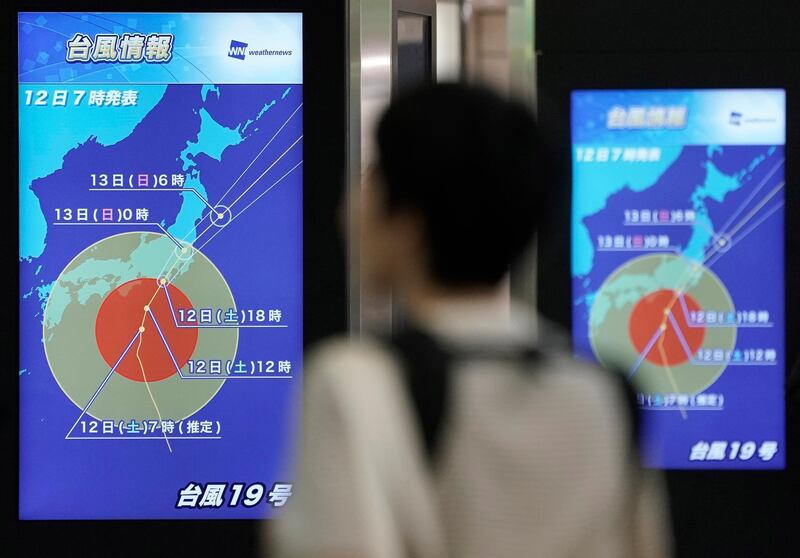 A railway passenger watches a display showing information about Typhoon Hagibis at Shinjuku railway station in Tokyo, Japan. EPA