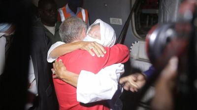 TOPSHOT - This video frame grab from an AFP video from October 8, 2020, shows French ex-hostage Sophie Petronin (R), who was released and flew to Bamako, hugging her son Sebastien Petronin (L) after she was reunited with him. An elderly French aid worker and a top Malian politician landed in the capital Bamako to an emotional reunion with their loved ones after being released from captivity by presumed jihadists. Mali announced the release of Frenchwoman Sophie Petronin, 75, and Malian politician Soumaila Cisse on October 8, 2020, alongside two Italian nationals. / AFP / AFPTV / -
