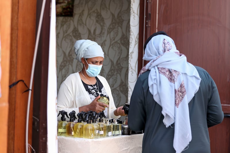A woman selling different perfumes at Al Dhafra Festival.