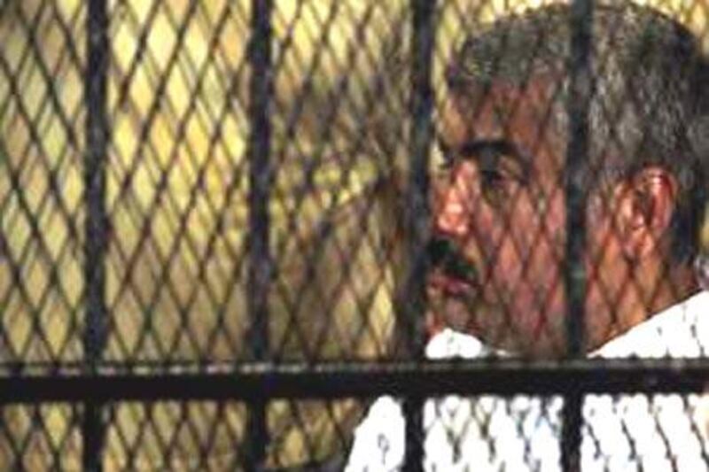 Egyptian billionaire businessman Hesham Talaat Moustafa sits inside the defendant's cage during his trial for the killing of Lebanese singer Suzanne Tamim.