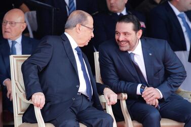 Saad Hariri talks with Lebanese President Michel Aoun while attending a military parade in Beirut. Reuters, File
