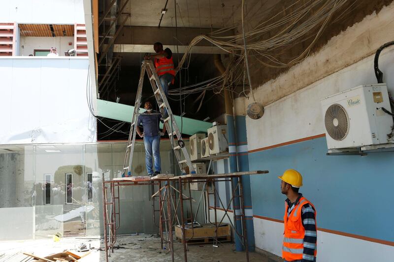 Workers tend to the damaged parts of Saudi Arabia's Abha airport. Reuters