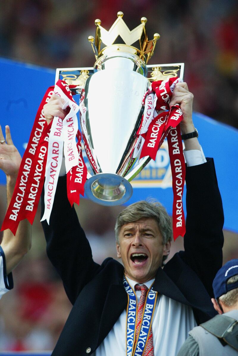 LONDON - MAY 11:  Arsenal manager Arsene Wenger celebrates by lifting the Premiership trophy after the FA Barclaycard Premiership match between Arsenal and Everton played at Highbury, in London on May 11, 2002. Arsenal won the match 4-3. DIGITAL IMAGE. (Photo by Ben Radford/Getty Images)