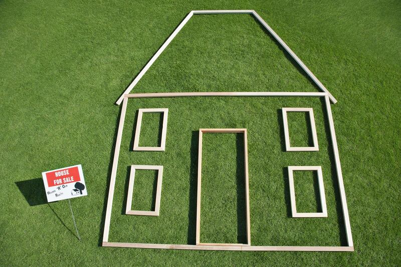 For sale' sign and house outline in grass. Getty Images