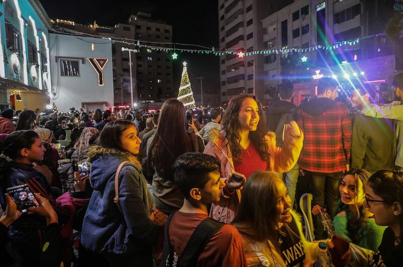 epa08042305 Palestinian youth attend a ceremony of lighting a Christmas tree in Gaza City, 03 December 2019. The event was organised by the YMCA Gaza.  EPA/MOHAMMED SABER