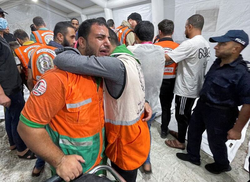 Members of a Palestinian civil emergency team react after several colleagues were killed in Israeli strikes, at Shifa Hospital in Gaza City. Reuters