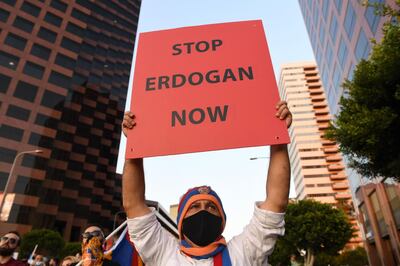 A man holds up a sign as he stands with members of the Armenian Youth Federation (AYF) during a protest outside the Azerbaijani Consulate General in Los Angeles on September 30, 2020 to protest what they call Azerbaijan's aggression against Armenia and Artsakh.  / AFP / VALERIE MACON
