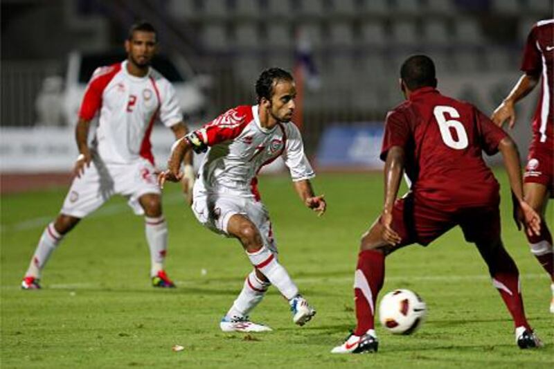 Al Ain, United Arab Emirates, Aug 25 2011, UAE national team  vs Qatar-  (left front) UAE's #7 Ali Al Wehaibipasses the ball past (right) Qatar's #6 Meshal Mubarak A.M. Budawood.  UAE defeated Qatar 3-1 at the whistle. Mike Young / The National
