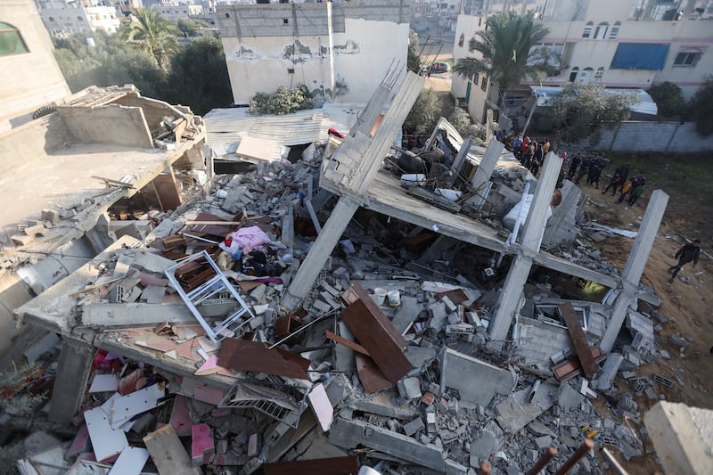 Palestinians inspect the site after an Israeli strike on a house.  Reuters