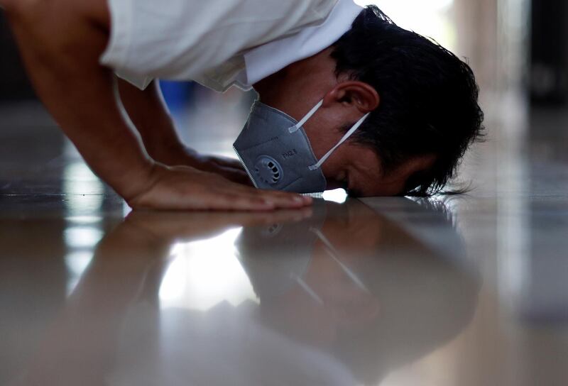 A man wearing a face mask prays as Muslims return for Friday's Ramadan prayers, in Bangkok, Thailand. Reuters