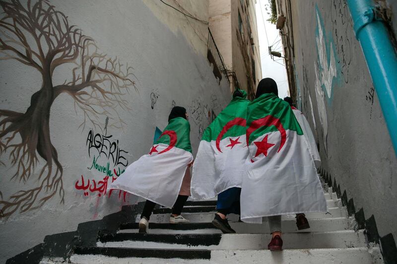 Female protesters wrapped in Algerian flags walk past during a demonstration in Algiers, Algeria, Wednesday, April 10, 2019. The Algerian senator Abdelkader Bensalah named to temporarily fill the office vacated by former President Abdelaziz Bouteflika said he would act quickly to arrange an "honest and transparent" election to usher in an "Algeria of the future." (AP Photo/Mosa'ab Elshamy)