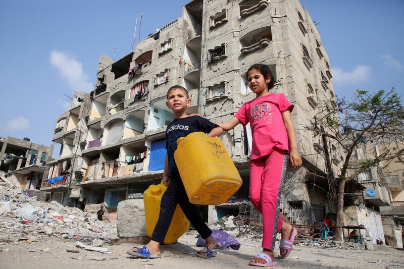 Palestinian children walk past a house damaged in an Israeli strike in Rafah in the southern Gaza Strip. Reuters