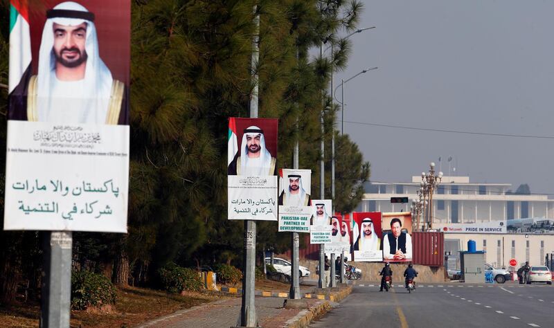 Motorcyclists ride past billboards showing the portraits of Abu Dhabi's Crown Prince, Sheikh Mohammed bin Zayed Al Nahyan, and Pakistani Prime Minister Imran Khan, to welcome crown prince to Islamabad, Pakistan, Sunday, Jan. 6, 2019. Abu Dhabi's crown prince is in Islamabad on daylong trip to discuss bilateral, International and regional issues with Pakistani leadership. Prince likely to announce billions to help Pakistani economy stabilized during visit. (AP Photo/Anjum Naveed)