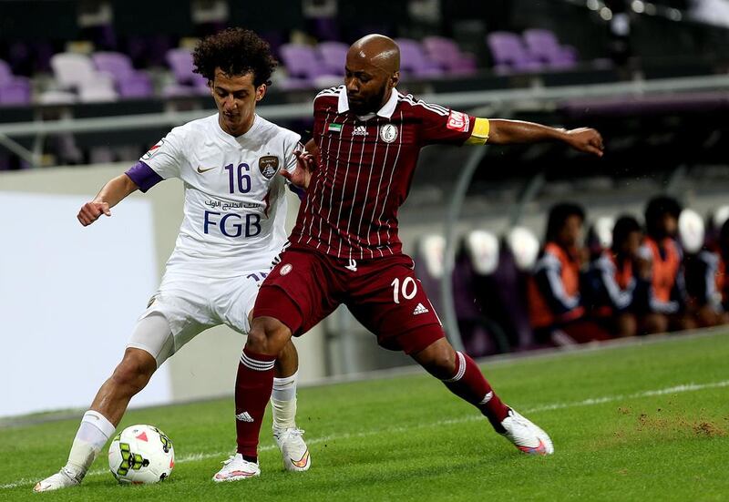 Mohamed Abdulrahman, left, of Al Ain jostles with Ismail Matar of Al Wahda during their Arabian Gulf League match at the Hazza Bin Zayed stadium in Al Ain on December 10, 2014. Satish Kumar / The National