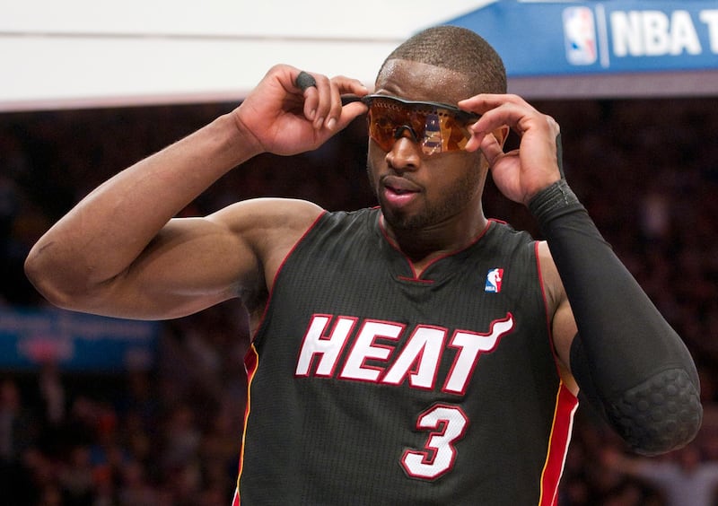 Miami Heat guard Dwyane Wade adjusts his new glasses after he was fouled by the New York Knicks in the third quarter of their NBA basketball game at Madison Square Garden in New York, January 27, 2011. REUTERS/Ray Stubblebine  (UNITED STATES - Tags: SPORT BASKETBALL)