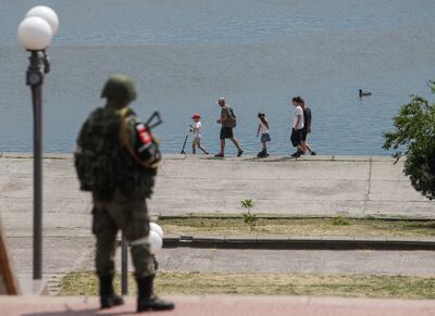 A Russian serviceman standing guard on a promenade along the Dnipro River in Kherson. EPA