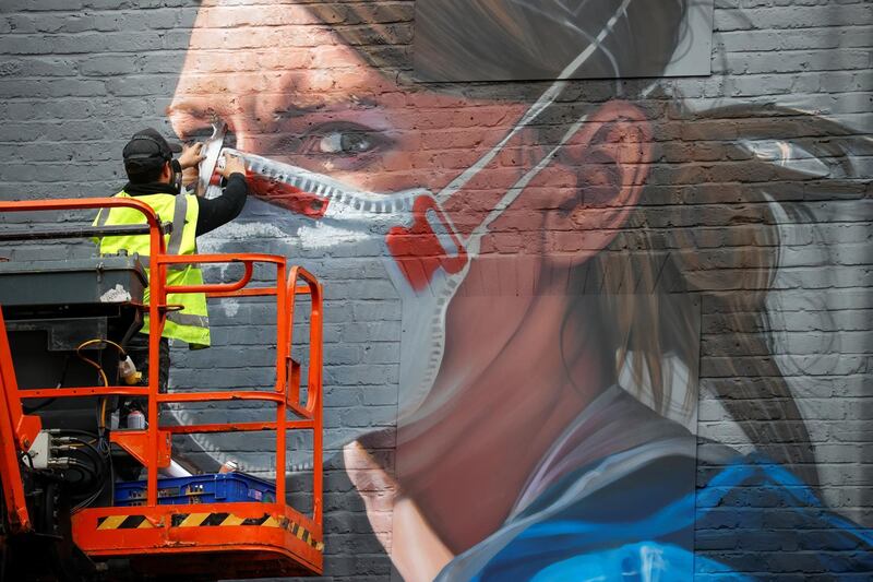 An artist works on a mural in Manchester. Reuters