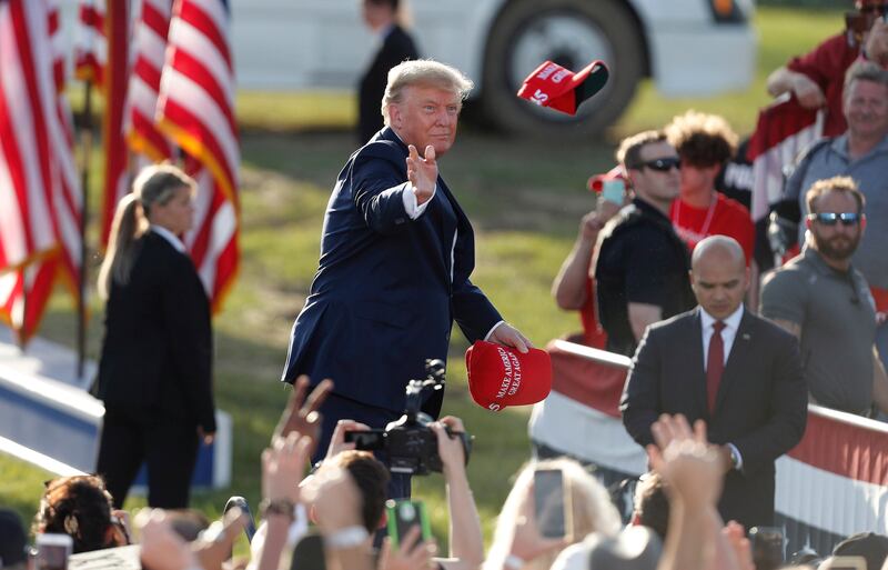 Mr Trump tosses Maga hats to the crowd as he arrives for a Save America rally at the Delaware County Fairgrounds in Delaware, Ohio. EPA
