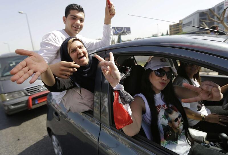 Syrian nationals living in Lebanon gesture as they arrive outside the Syrian Embassy in Yarze east of Beirut before voting in the upcoming presidential elections. Joseph Eid / AFP