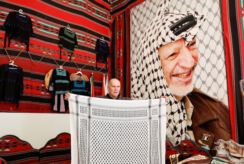 Izzat Hirbawi showing a keffiyeh at the textile factory in Hebron. Reuters