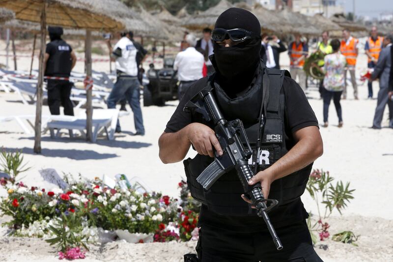 A hooded Tunisian police officer stands guard at the scene of the terror attack on Sousse. (Abdeljalil Bounhar /AP)