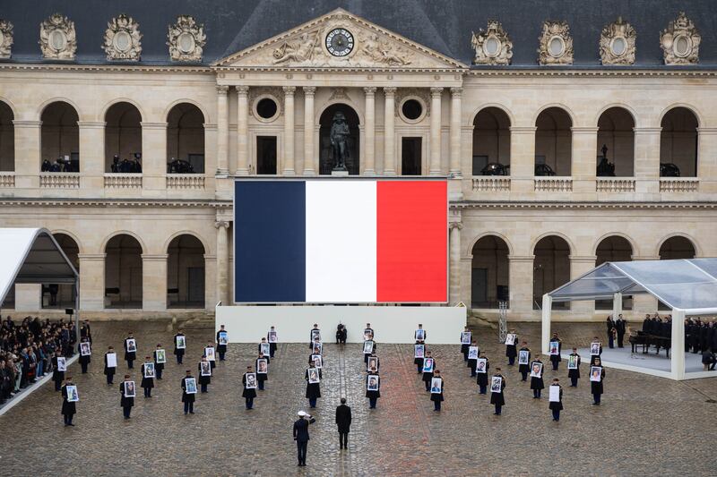 French President Emmanuel Macron (C) stands in front of Republican Guards carrying victims' portraits during a ceremony to pay tribute to the 42 French citizens killed and to all the victims of the 07 October Hamas's attack on Israel, four months after the attacks, in the courtyard of the Hotel des Invalides in Paris, France, 07 February 2024.  Thousands of Israelis and Palestinians have been killed since the militant group Hamas launched an unprecedented attack on Israel from the Gaza Strip on 07 October 2023, and the Israeli strikes on the Palestinian enclave which followed it.   EPA / CHRISTOPHE PETIT TESSON