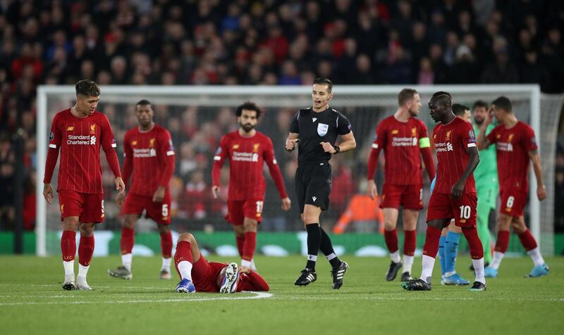 Liverpool's Virgil van Dijk after sustaining an injury while Roberto Firmino, Sadio Mane and teammates look on. Reuters