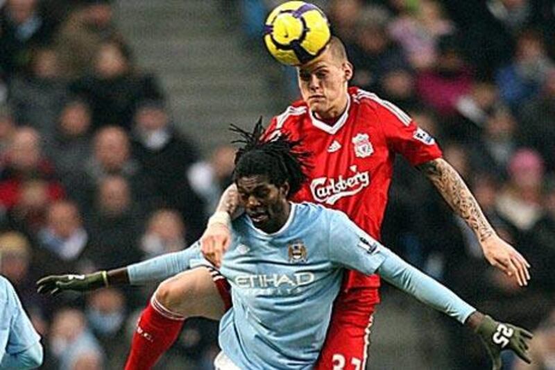 Manchester City's Emmanuel Adebayor, left, and Liverpool's Martin Skrtel jump for the ball during their Sunday's 0-0 draw at Eastlands. Both teams are battling it out to finish in the top four.