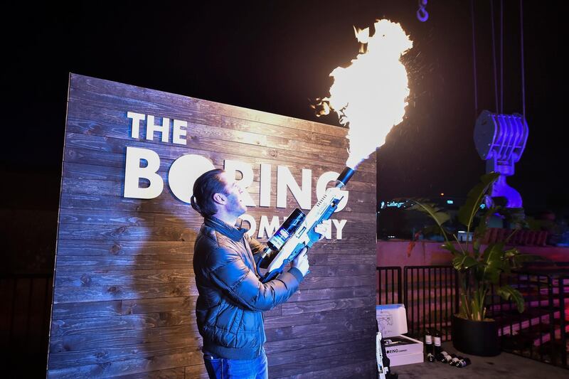 An attendee operates a Boring Company flamethrower during the unveiling event. EPA