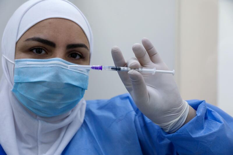 A member of the healthcare staff prepares a dose of the Covid-19 Pfizer/BioNTech vaccine at Rafik Hariri Hospital in the capital Beirut, as Lebanon's inoculation campaign got under way on Sunday. AFP