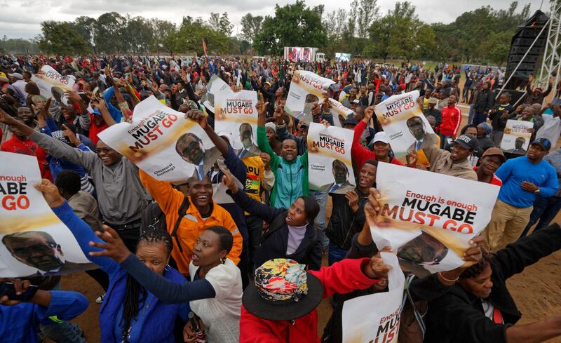 Protesters hold posters asking president Mugabe to step down, on which one has handwritten "37 years for nothing", at a demonstration at Zimbabwe Grounds in Harare. Ben Curtis / AP Photo