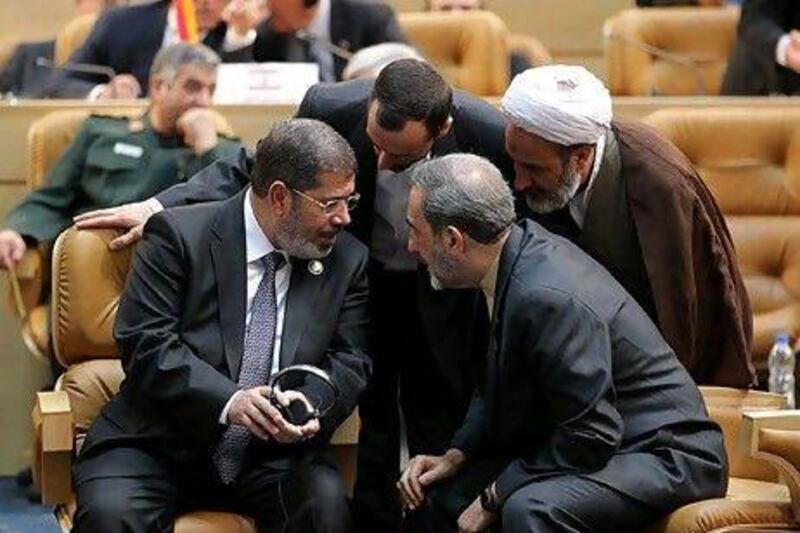 The Egyptian president Mohammed Morsi, left, with, Ali Akbar Velayati, an adviser to the Iranian supreme leader, on right, and officials during the Non-aligned Movement summit in Tehran on Thursday.